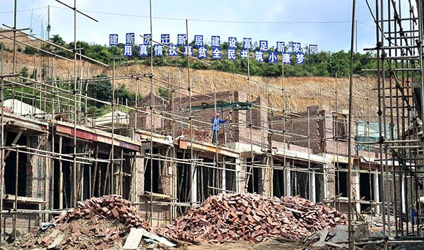 Workers build new houses for impoverished families in Xionglumo village, Yunnan province.(Liu Ranyang/China News Service)