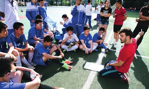 Young football players listen to Llompart's guidance during halftime. (Photo: Li Hao/GT)