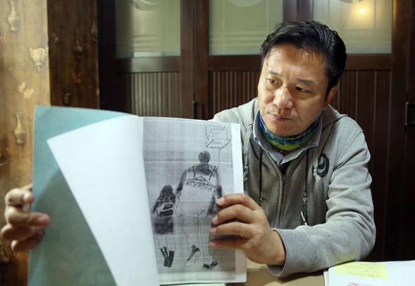 Guo Li, who was recently exonerated of blackmail after serving five years in prison, displays a drawing depicting him and his daughter. He said she was his motivation to carry on during his time in jail.(Zou Hong / China Daily)