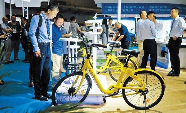 Visitors at a navigation conference inspect a smarter shared bicycle that comes with a lock compatible with Chinas home developed BeiDou Satellite Navigation System. (Jiang Xiaowei)