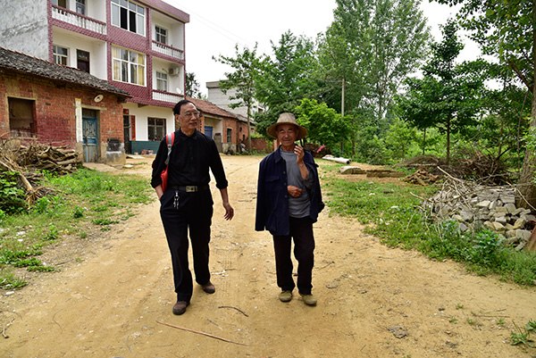 Liu Zhengrong (left) visits a villager in Hongxing in Huanggang, Hubei province. WU YAN/CHINA DAILY