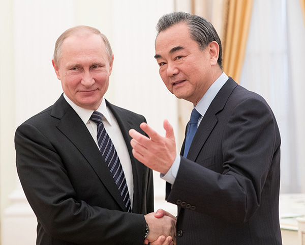 Russian President Vladimir Putin greets Foreign Minister Wang Yi during a meeting at the Kremlin in Moscow on Thursday. WU ZHUANG/XINHUA