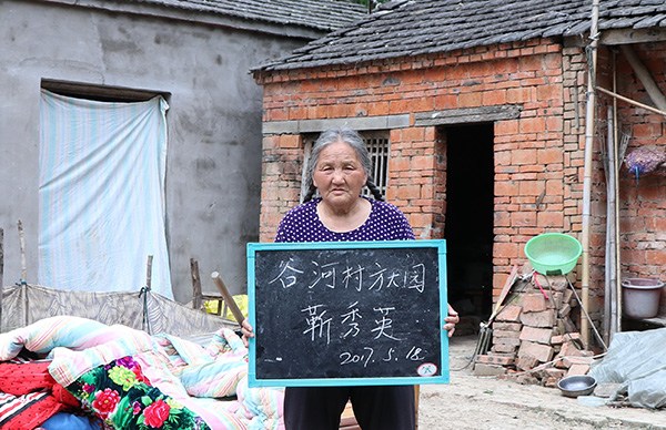 Jin Xiuying verifies renovations to her house to qualify for a subsidy from the local government. ZHU LIXIN/CHINA DAILY