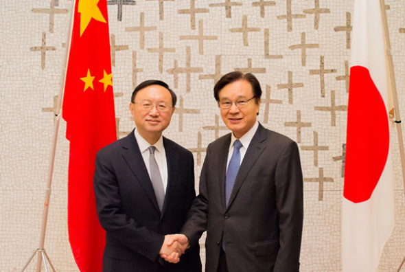 State Councilor Yang Jiechi shakes hands with Shotaro Yachi, head of the secretariat of Japan's National Security Council, during the fourth high-level political dialogue between China and Japan on Monday, as Yang kicked off his three-day visit to Japan. (Provided to China Daily)