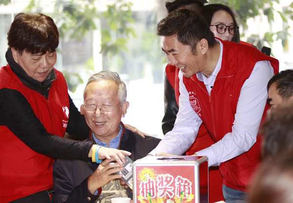 Li Gan, developer of the Love Hula Hoop app (third from left), helps hand out gifts in January to bereaved parents in Shenzhen, Guangdong province. (Provided to China Daily)