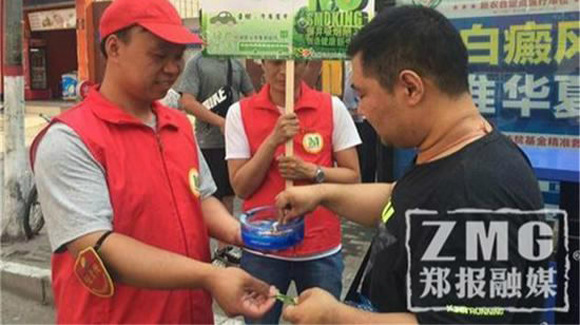 A volunteer give passenger a gum to help stop smoking. (Photo//Zhengzhou Evening Newspaper)