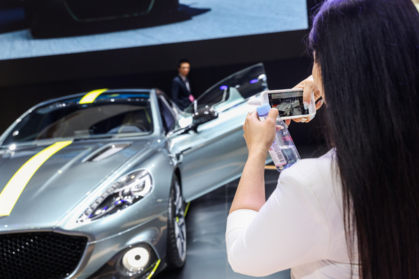 A visitor takes a picture of an Aston Martin car at the Shanghai auto show in April. (Photo provided to chinadaily.com.cn)