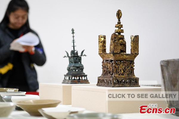A gilt copper Asoka pagoda unearthed from the terrestrial palace of Longping Temple at the ancient Qinglong Township ruins is seen in Shanghai, east China, Dec. 8, 2016. Shanghai Museum on Thursday introduced the latest discovery since the excavation of the ruins in 2010. The Qinglong Township ruins is located in today's Baihe Township of Qingpu District in Shanghai, and documents recorded it as an important trade port in Tang (618-907) and Song (960-1279) Dynasties. In recent years, more than 6,000 restorable porcelain works and tens of thousands of broken porcelain pieces from nearby provinces were found in the ruins, which offers new evidence that Qinglong Township was an important port along the Maritime Silk Road. Besides, the discovery of the Longping temple, pagoda and its terrestrial palace in 2015 and 2016 helped the researchers to study the layout of the township as well as the history of China's ancient buildings and Buddhism. (Xinhua/Ren Long)