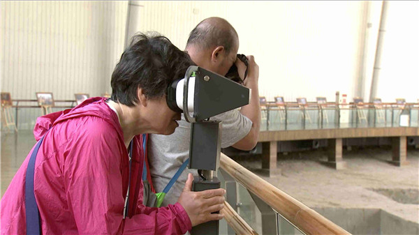 A visitor uses modern technology in the museum. (CGTN Photo)