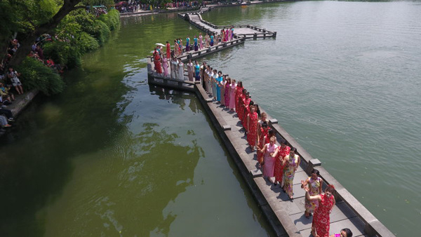 Women dressed in qipao pose for photos on a bridge in Hangzhou, capital city of East China's Zhejiang province, on May 26. (Photo/provided to chinadaily.com.cn)