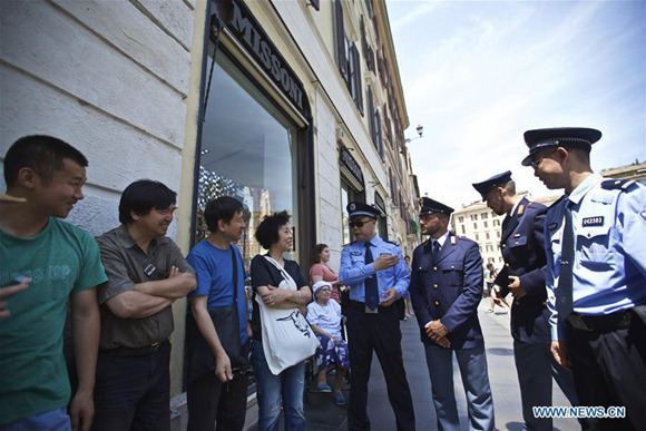 Chinese police officers and Italian police officers talk with tourists at Piazza di Spagna of Rome, Italy, on June 5, 2017.  (Xinhua/Jin Yu)