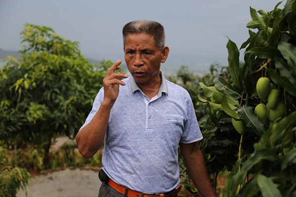 Mo Wenzhen, the former Party chief of Shangxing village, lead his fellow villagers out of mountains and shake off poverty. (Photo provided to chinadaily.com.cn)