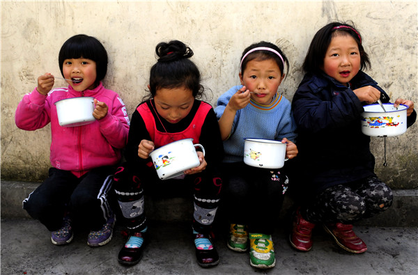 Children enjoy free lunches in Hefeng county, Hubei province. (Photo/Xinhua)