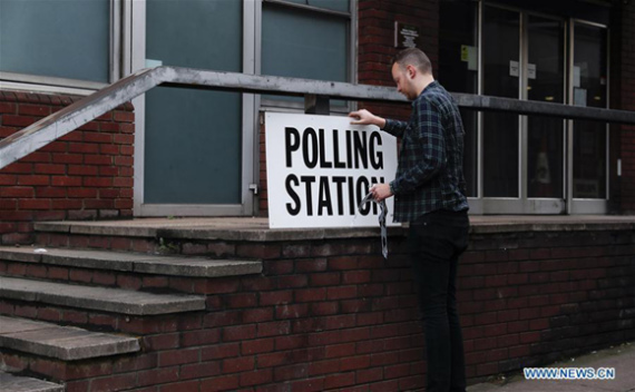 A staff works outside a polling station in London, Britain on June 8, 2017. Polling stations across the Britain opened early Thursday as voters started to make their decision in the general election. (Xinhua/Han Yan)