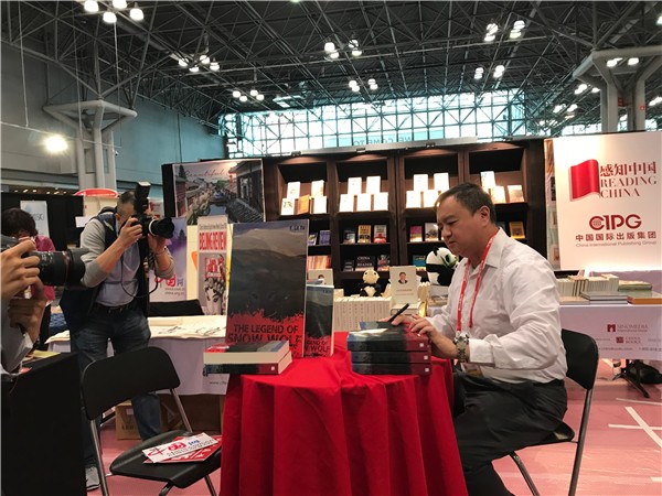 F. Lit Yu, author of the Legend of Snow Wolf, signs the book for the readers at the Book Expo held at the Javits Convention Center in New York on May 31. XIAO JIAQIAO / FOR CHINA DAILY