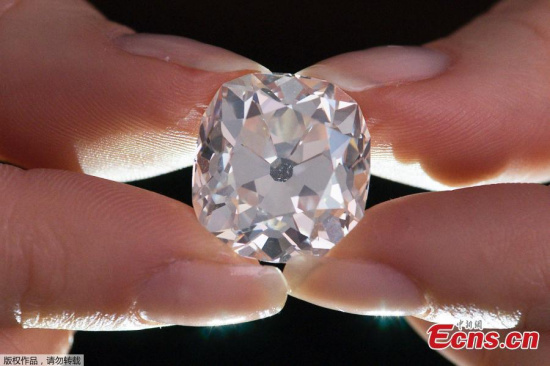 A member of Sotheby's staff poses holding a 26.27 carat, cushion-shaped, white diamond, for sale at Sotheby's auction house in London on May 22, 2017. (Photo/Agencies)