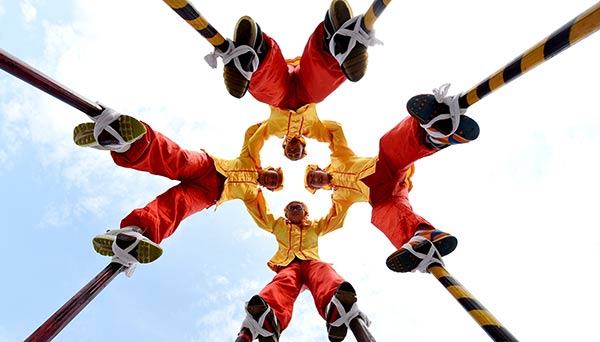 Students in Yiwu, Zhejiang province, perform traditional stilt-walking to celebrate China's first Cultural and Natural Heritage Day on Saturday. Around the nation, activities were held in honor of the day. GONG XIANMING/CHINA DAILY