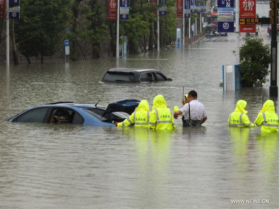 People move a car on a flooded street in Guiyang City, capital of southwest China's Guizhou Province, June 12, 2017. Heavy rain hit Guizhou since Sunday.(Xinhua/Zhang Hui)