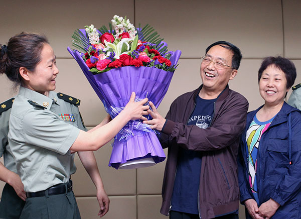 Medical staff at Tangdu Hospital in Xi'an, Shaanxi province, give flowers to a man surnamed Guo last month. Guo recovered from bird flu after being treated at the hospital. The hospital is affiliated with the Fourth Military Medical University.Ruan Banhui / For China Daily