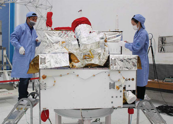 Technicians install thermal control materials for Micius at the Jiuquan Satellite Launch Center in July. (Photo/Xinhua)