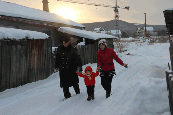 Zhao, Gu and their daughter walk down a snow-covered lane on their way home. Photo Provided To China Daily
