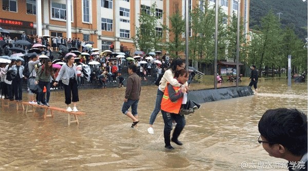 A female cleaner carries a student across the flooded area in Liupanshui Normal College on Thursday. (Photo from Sina Weibo)