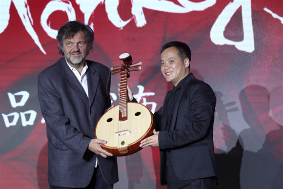 Director Ning Hao (right) gives a ruan, a traditional Chinese plucked string instrument, to Serbian filmmaker Emir Kusturica at a press conference of the Dirty Monkeys Film Corporation. (Photo: Shanghai Daily/Dong Jun)