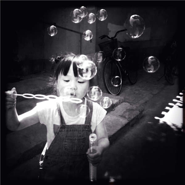 Tan Siok Siok's black-and-white photos reveal a touching and lively side of daily lives in Beijing's hutong area. Photos provided to China Daily