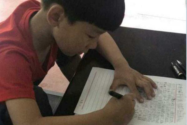 Li Peizhe writes a letter to his father. (Photo by Li Lan/ provided to chinadaily.com.cn)