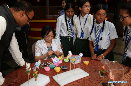 Nepali people visit a stall during the opening of China Intangible Cultural Heritage Week in Kathmandu, Nepal, June 22, 2017. (Xinhua/Sunil Sharma)