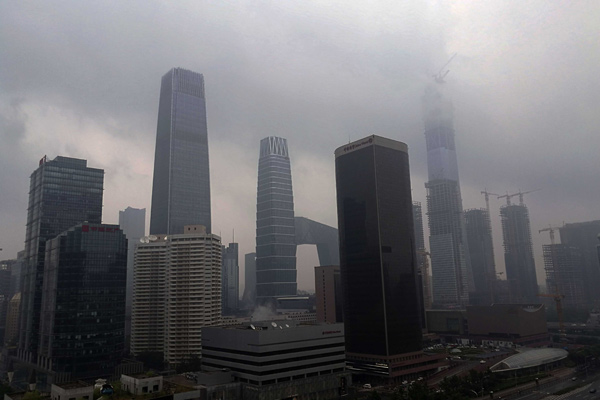 Buildings in Beijing's Guomao area are enshrouded by rain clouds on Thursday afternoon. Shen Gang/China Daily