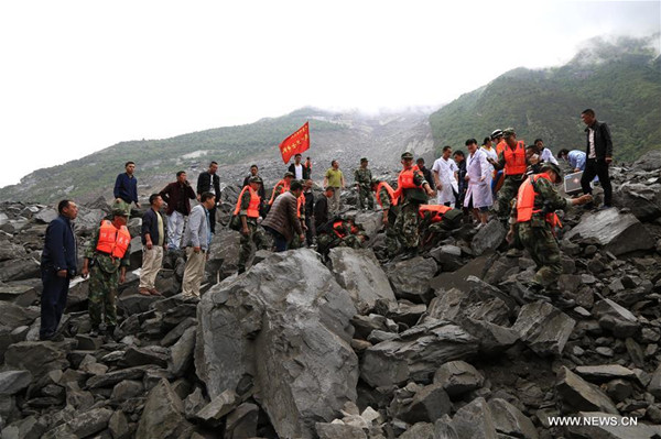 Rescuers work at the accident site after a landslide occurred in Xinmo Village of Maoxian County, Tibetan and Qiang Autonomous Prefecture, southwest China's Sichuan Province, June 24, 2017. The landslide on Saturday morning smashed some 40 homes, where about 100 people are feared to be buried. (Xinhua/He Qinghai)