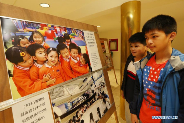 Students watch a photo exhibition marking the 20th anniversary of Hong Kong's return to China in San Francisco, the United States, June 24, 2017. The show displayed some five dozens of photos provided by China's Ministry of Foreign Affairs to feature historical moments, as well as social and economic life, of Hong Kong, since China resumed exercise of sovereignty over the territory on July 1, 1997. (Xinhua/Liu Yilin)