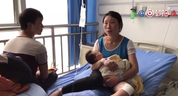 A screenshot of a video shows Xiao Yanchun holding her son at Maoxian County People's Hospital, in Aba Tibetan and Qiang autonomous prefecture, Sichuan province on June 24, 2017. (Screenshot from official Sina Weibo of Chengdu Economic Daily)