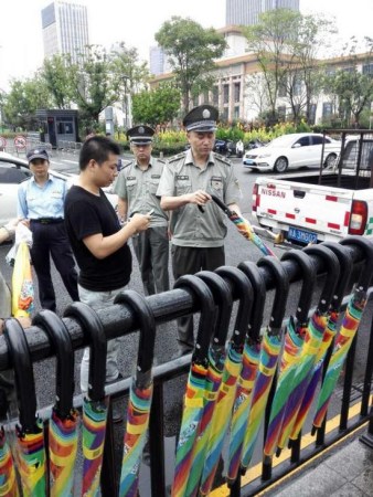 Officers of urban management department remove the sharing umbrellas from public areas in Hangzhou. (Photo/jinbaonet.com)
