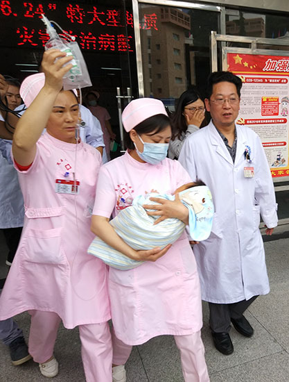 Qiao Daochun, an infant whose crying awoke his parents and helped save them from the landslide, is transferred to a hospital in Chengdu, Sichuan province.Yang Li / For China Daily