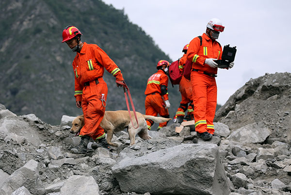 Rescuers use camera probes to check for signs of life on Monday in Xinmo village, Sichuan province.(Photo by Feng Yongbin/China Daily)