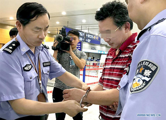 Suspect surnamed Du is handcuffed at Pudong International Airport in Shanghai, east China, June 20, 2017. A suspect has been returned from Canada to China as part of a campaign to capture economic fugitives, Chinese police said Wednesday. (Xinhua/Fan Jun)