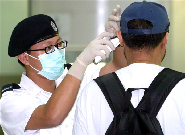 A paramedic checks a man's health during the 2003 outbreak of SARS in Hong Kong. (Photo by Huo Yan/China Daily)