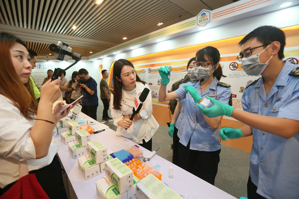 Officers from the food and drug administration conduct tests at a publicity event in Beijing's Dongcheng district earlier this month to improve the awareness of food safety. DA WEI/CHINA DAILY