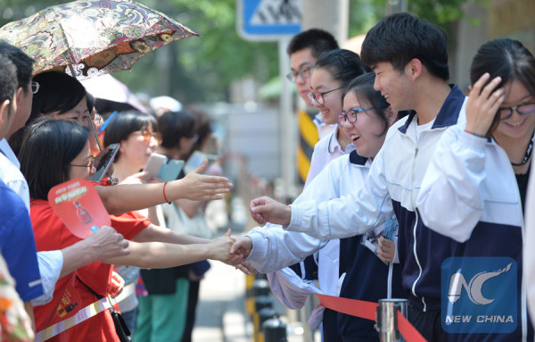 Students shake hands with their teachers after finishing their first subject of the examination in Beijing on June 7, 2017. (Xinhua/Wang Huajuan)
