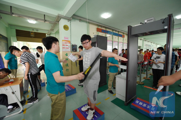Students go through security and anti-cheating check before taking the exam in Jilin Province on June 7, 2017. (Xinhua/Meng Delong)