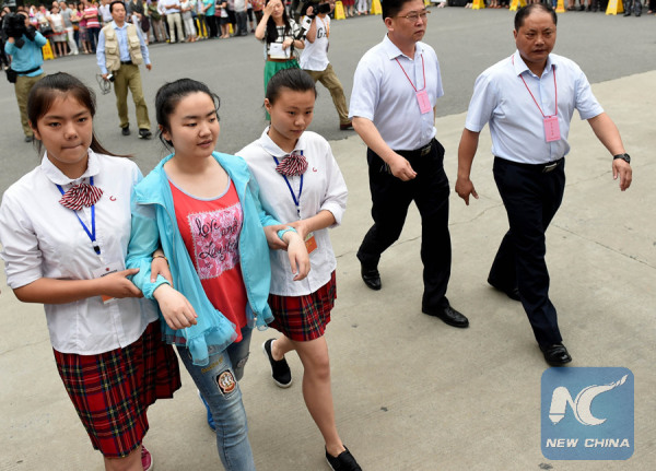 Volunteers help a blind girl to sit the Gaokao in Anhui Province on June 7, 2015. (Xinhua/Liu Junxi)
