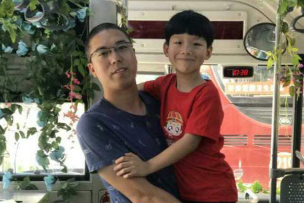 Li Peizhe poses with his father, Li Ning. (Photo by Li Lan/ provided to chinadaily.com.cn)