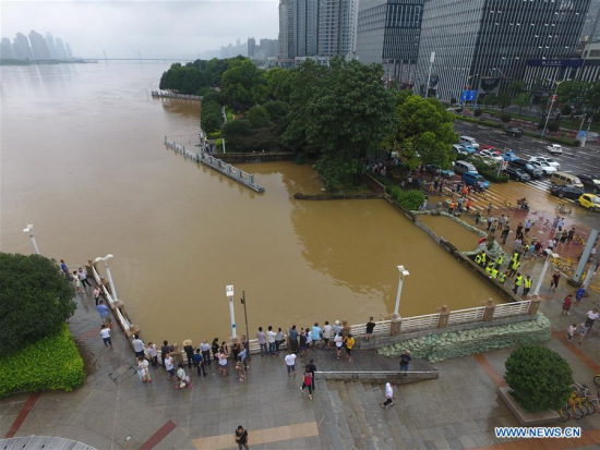 Citizens are seen in flood-hit Changsha, capital of central China's Hunan Province, July 2, 2017. Days of torrential rain in Hunan Province raised the water level of the Xiangjiang River, a major tributary of Yangtze River, to exceed its record flood level Sunday morning. (Xinhua/Long Hongtao)