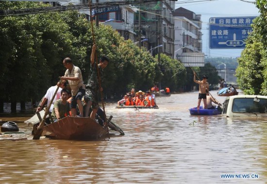 Rescuers work on a waterlogged road in Guiyang Township of Qidong County, central China's Hunan Province, July 3, 2017. Continuous rainfall raised the water level of the Xiangjiang River in Hunan. Guiyang was hit by the rain-triggered flood. (Xinhua/Cao Zhengping) 