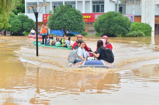 Rescuers help relocate students at flooded Guilin Tourism College in Guilin City, south China's Guangxi Zhuang Autonomous Region, July 3, 2017. Heavy rain and floods have left 16 people dead and 94,000 residents relocated in Guangxi. (Xinhua/Li Xuanli)