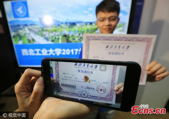 A teacher shows a new form of offer from Northwestern Polytechnical University in Xian City, capital of Northwest Chinas Shaanxi Province, July 4, 2017. (Photo/VCG)