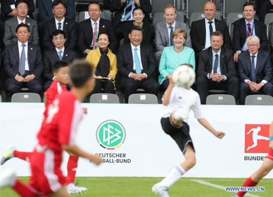 Chinese President Xi Jinping (C, front), his wife Peng Liyuan (3rd L, front) and German Chancellor Angela Merkel (3rd R, front) watch a friendly football match between Chinese and German youth teams in Berlin, capital of Germany, July 5, 2017. (Xinhua/Wang Ye)