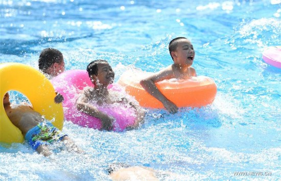 Kids played in water to keep cool in a water park in Chongqing, July 11, 2017. An orange level high temperature warning is issued by the meteorological observatory of southwest China's Chongqing Municipality Tuesday. (Xinhua/Wang Quanchao)